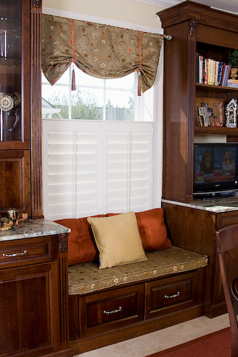 kitchen sitting nook window seat with dark cabinets and plantation shutters on window | Marchand Creative Kitchens Cabinets New Orleans Metairie Mandeville LA