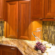Specialty Products task lighting with modern backsplash and cherry stained cabinets | Marchand Creative Kitchens Cabinets, Marchand Creative Kitchens, Cabinets, New Orleans, Metairie, Mandeville, Kenner, Covington, Slidell, Lacombe, North Shore, South Shore, Kitchen, kitchen remodel, kitchen renovation