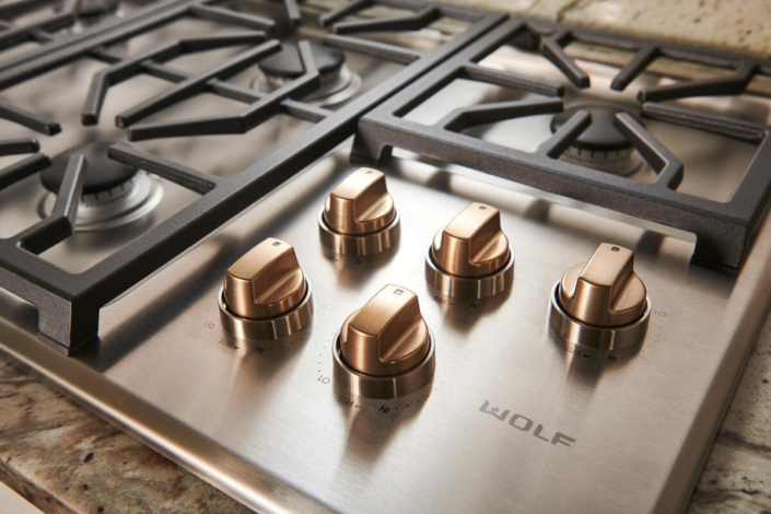 Wolf stainless range top with gold knobs | Marchand Creative Kitchens