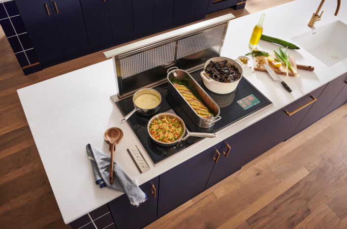 Wolf cooktop with pots, pans and food cooking | Marchand Creative Kitchens
